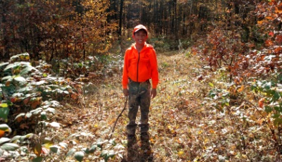 boy with orange jacket enjoying the outdoors