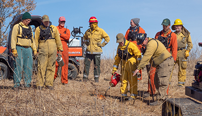 Volunteers learning how to do a controlled prairie burn